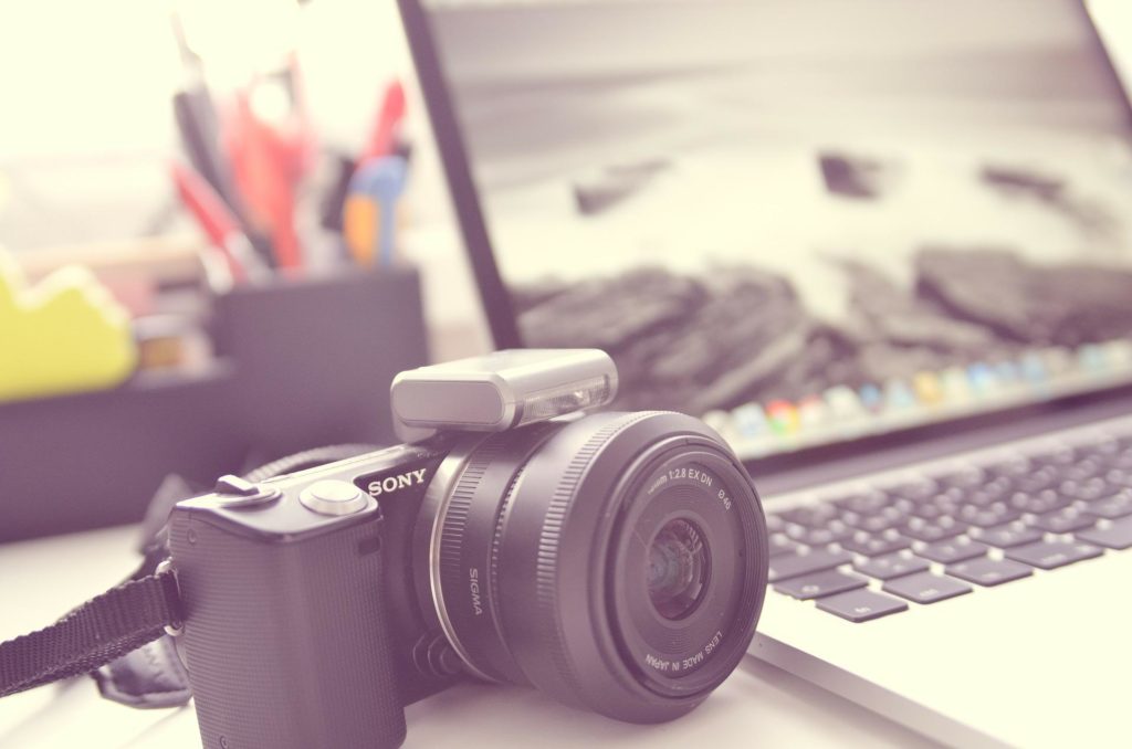 A camera sat next to a laptop (Image: Daniel Friesenecker - Pixabay)